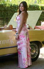 Side view of a pink floral maxi dress with tiered ruffles and thin criss-cross back straps
