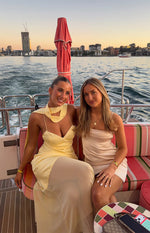 Yellow satin maxi dress with a draped scarf neckline, deep V-neck, thin spaghetti straps, and sheer overlay skirt