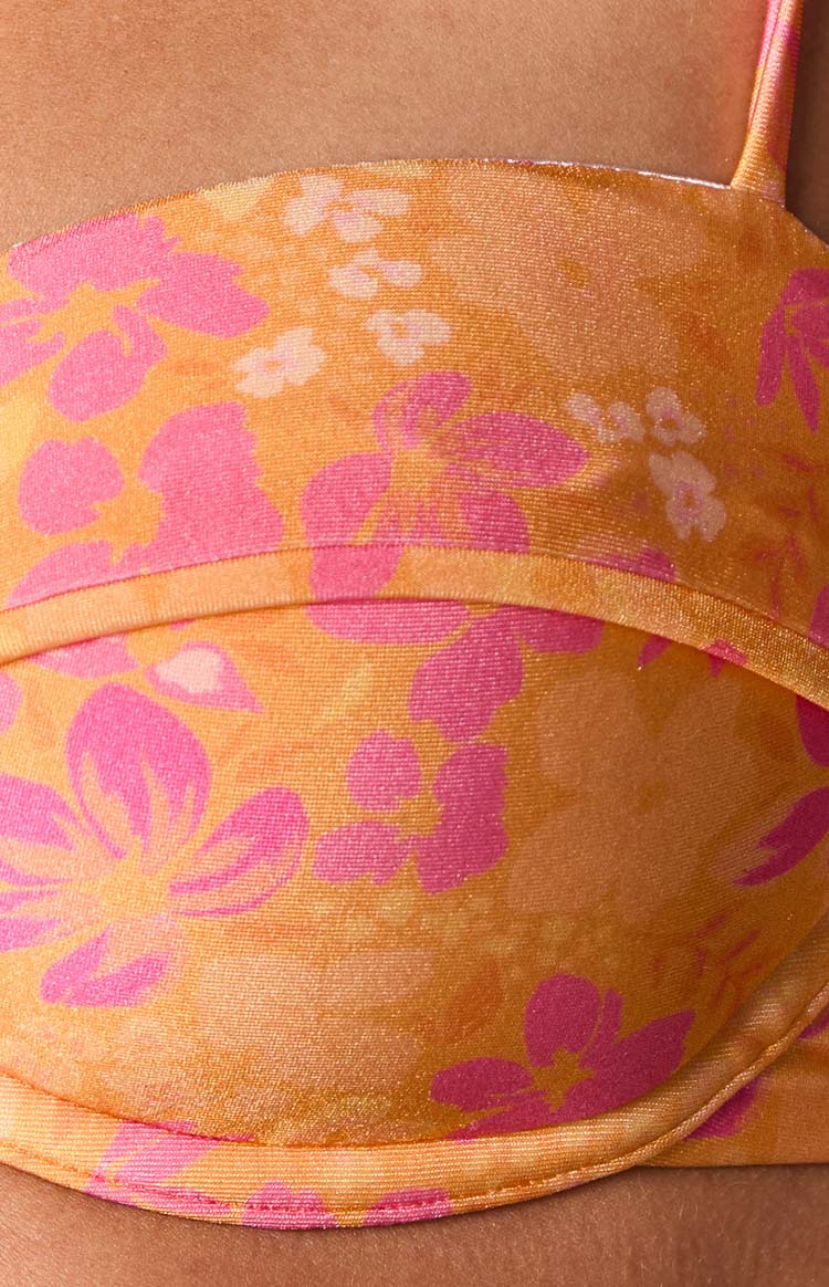 Close-up of the orange floral bikini top showing the underwire and seam detail above the cup