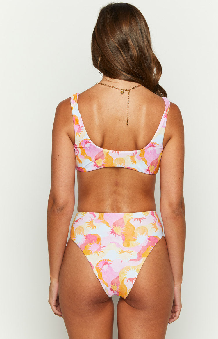 Rear view of the multi-print bikini top with a low scoop back and wavy sun pattern in pink, orange, and yellow