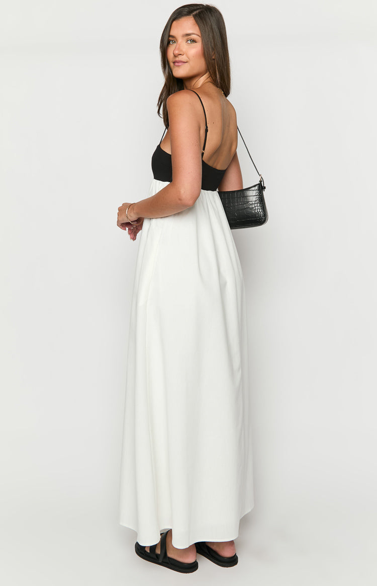 Side view of the black and white contrast maxi dress, showing the black fitted bodice with thin spaghetti straps and a low scoop back