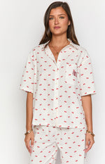 White short sleeve pajama shirt with red cherry print, collared neckline, and chest pocket with embroidered logo