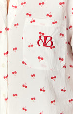 Close-up of the chest pocket on a white cherry print pajama shirt with a red embroidered BB design