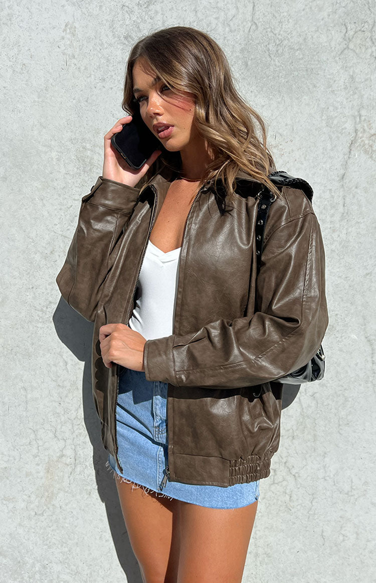 Partially unzipped vintage brown PU bomber jacket with a relaxed fit and ribbed hem