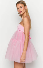 Side view of a pink strapless mini dress showing the side cut-out, bow tie detail, and tiered tulle skirt