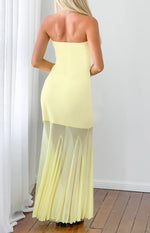 Rear view of a yellow strapless maxi dress with a sheer pleated asymmetrical overlay skirt