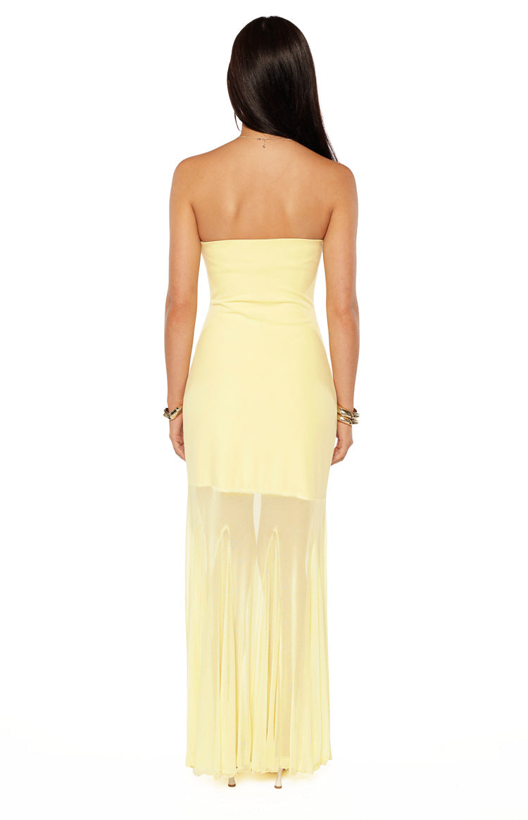 Rear view of a yellow strapless maxi dress with a sheer asymmetrical overlay skirt