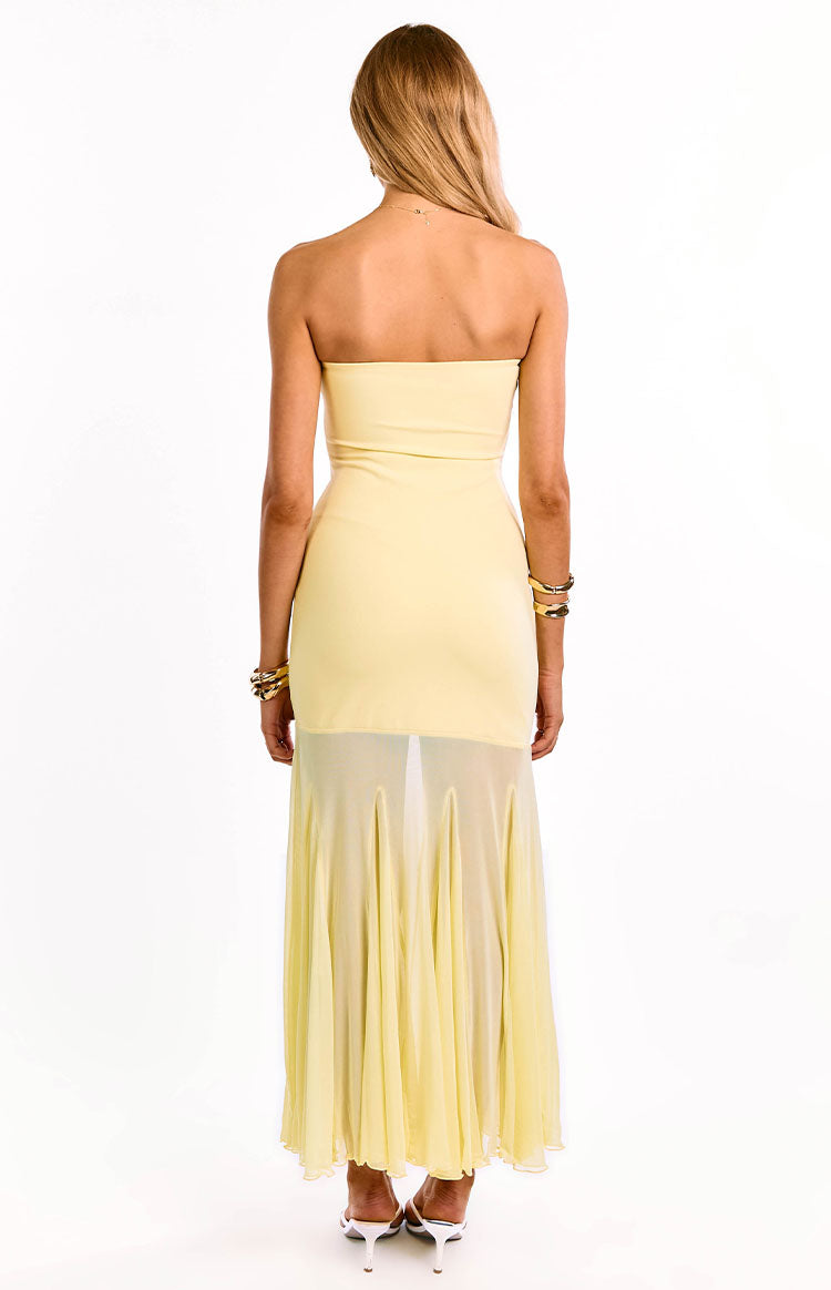 Rear view of a yellow strapless maxi dress with a fitted bodice and sheer pleated skirt overlay over a mini lining