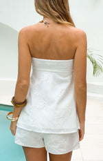 Rear view of a white floral embroidered strapless longline top with a scalloped back neckline