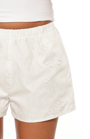 Close-up of the elasticated waist and white floral broderie anglaise shorts