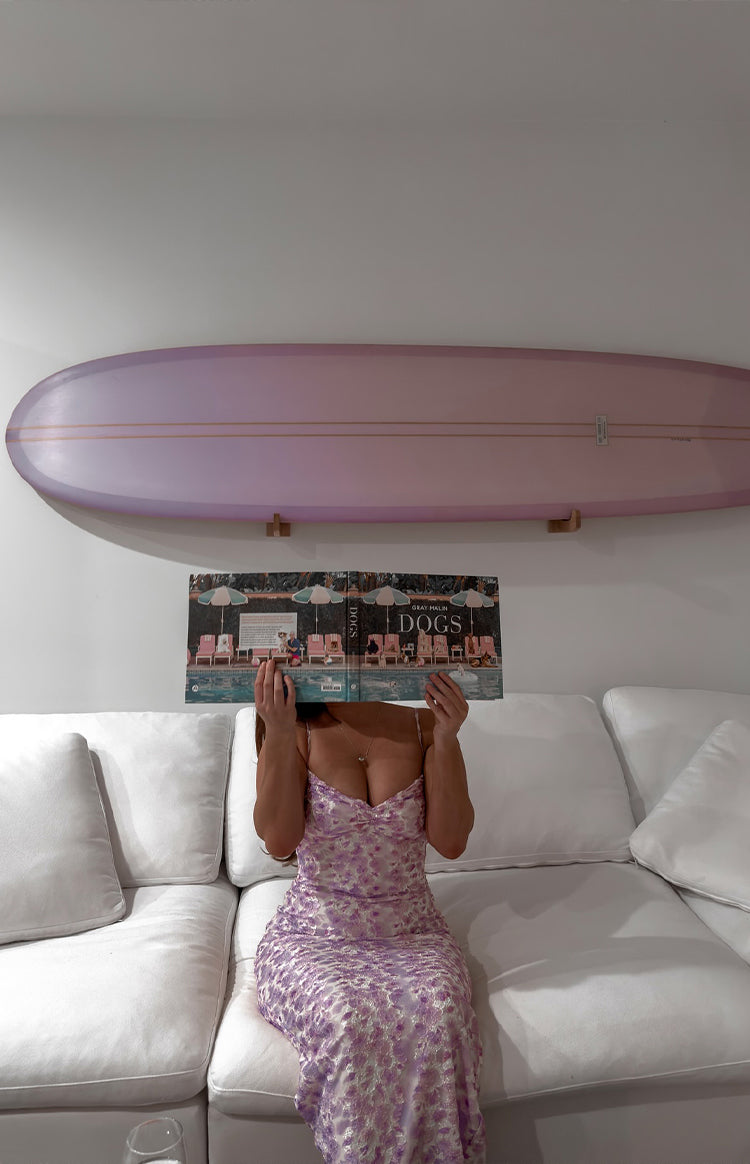 Blonde model wearing pink maxi dress holding cocktail glass.