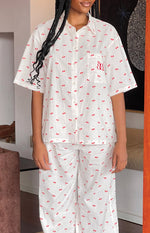 White short-sleeve collared pajama shirt with red cherry print, button front, and matching wide-leg pants