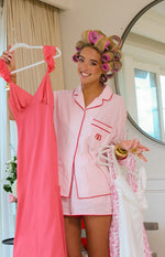 Pink and white striped pajama shorts with red piping along the hem and a relaxed fit