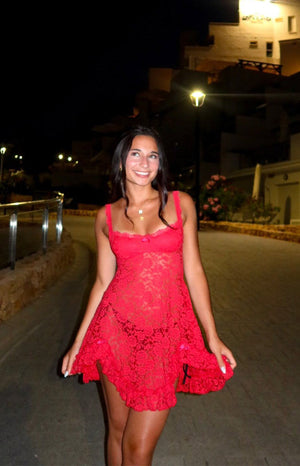 Red lace mini dress with a square neckline, thin straps, small bow detail, and a flowy ruffled hem