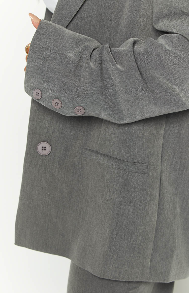 Side view of a grey oversized blazer with a soft, longline drape and notched lapels