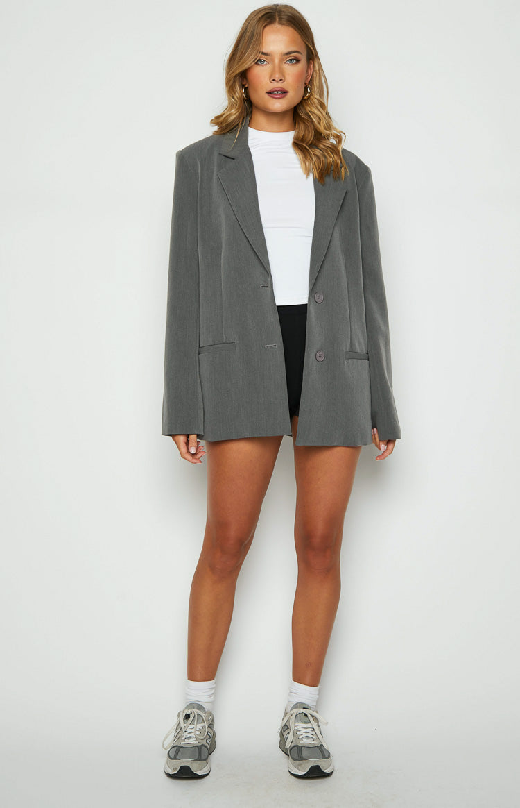 Front view of an oversized grey blazer with notched lapels, two buttons, and flap pockets