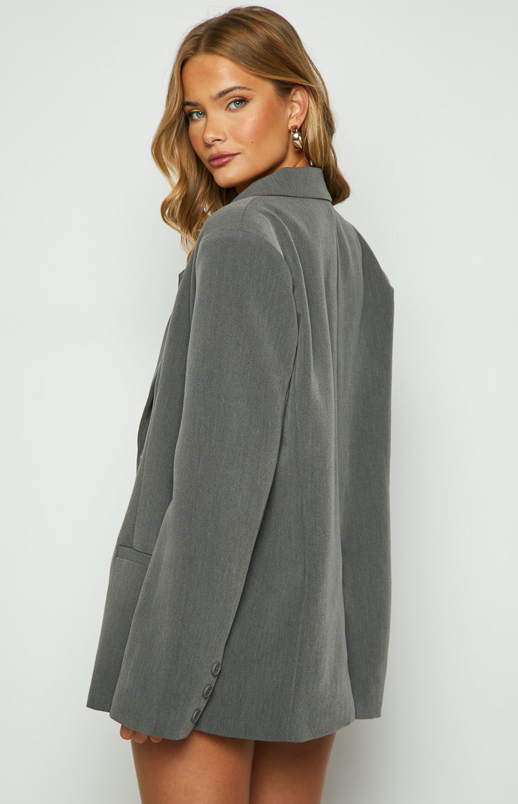 Back view of an oversized grey blazer with a notched lapel collar and a single vent at the back hem