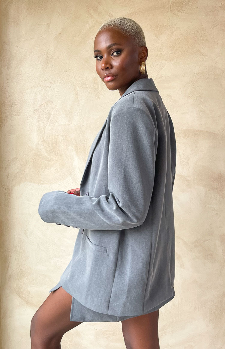 Relaxed fit grey blazer with long sleeves and notched lapels, worn open