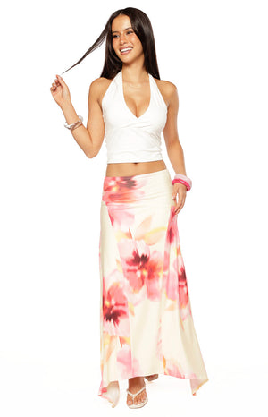Our model wears a long creamy white maxi-skirt with a large abstract pink and coral floral print and a bias-cut flowy hemline.