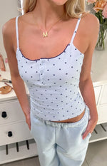 Light blue polka dot singlet with dark blue scalloped neckline trim and three-button henley placket