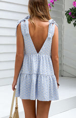 Rear view of a blue gingham floral mini dress with a deep V-back and tie-shoulder straps, tiered skirt