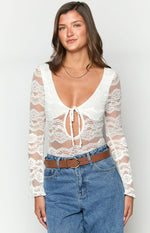 Close-up of the white lace bodysuit showing the deep V-neckline and tie-front cutout detail