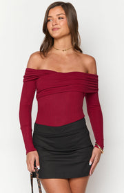 Front view of a red ribbed knit off-shoulder bodysuit with long sleeves and a draped neckline