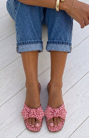 Overhead view of red and white gingham check sandals with a knotted bow on the wide strap and square toe