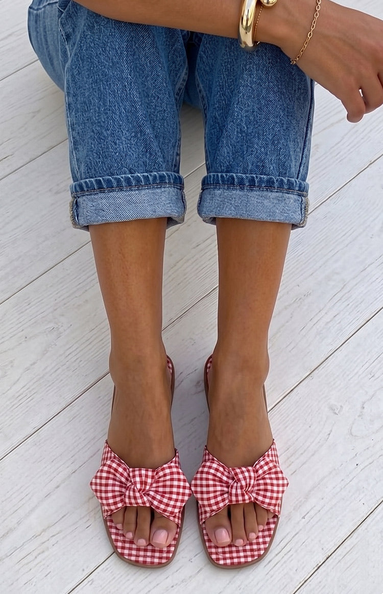 Overhead view of red and white gingham check sandals with a knotted bow on the wide strap and square toe