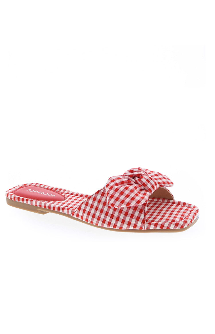 Side view of red and white gingham check slide sandals with a knotted bow detail and square toe