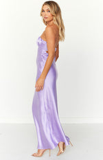 Side view of a purple satin strapless maxi dress with ruched bust and side waist cutouts