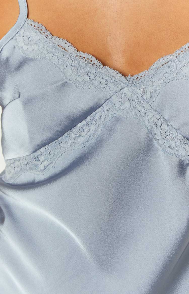 Close-up of the blue satin fabric and the delicate floral lace trim along the V-neckline