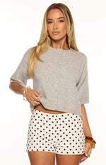 Light grey knit cropped cardigan featuring a round neckline, elbow sleeves, and small front buttons