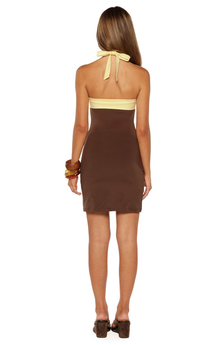 Rear view of the brown jersey mini dress showing the yellow contrast band and halter tie at the neck
