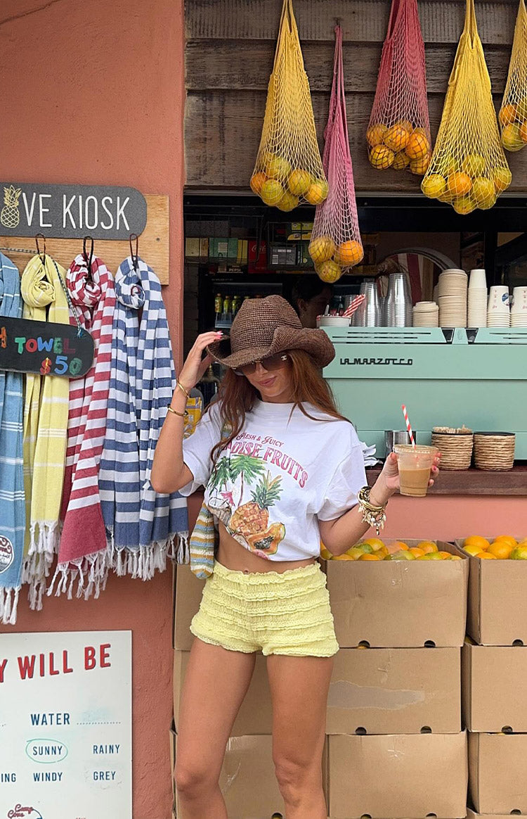 White short sleeve tee with a tropical fruit graphic print and tied side detail