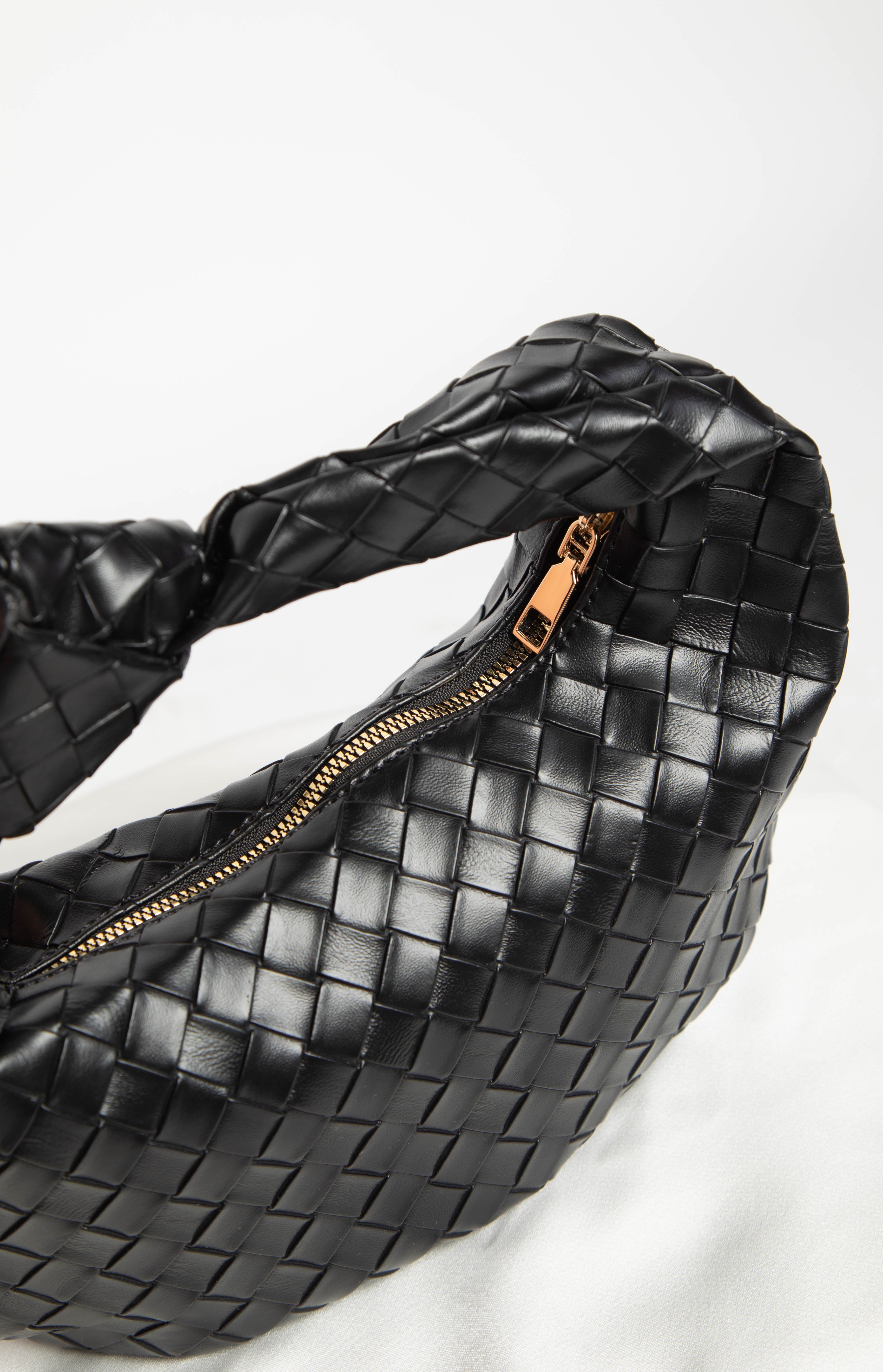Close-up of the black woven PU shoulder bag showing the gold-toned zipper and textured material