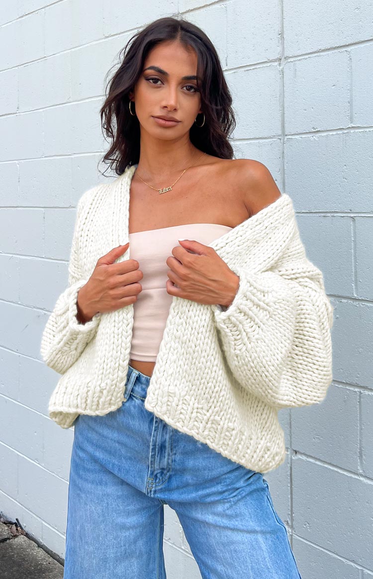 Cream chunky knit cardigan worn open, highlighting the thick texture and wide, relaxed sleeves