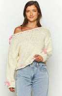 Cream chunky knit sweater with pink trim at the round neckline and hem