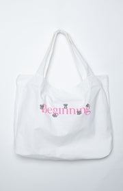 White canvas tote bag with pink 'Beginning' text and small grey koala illustrations