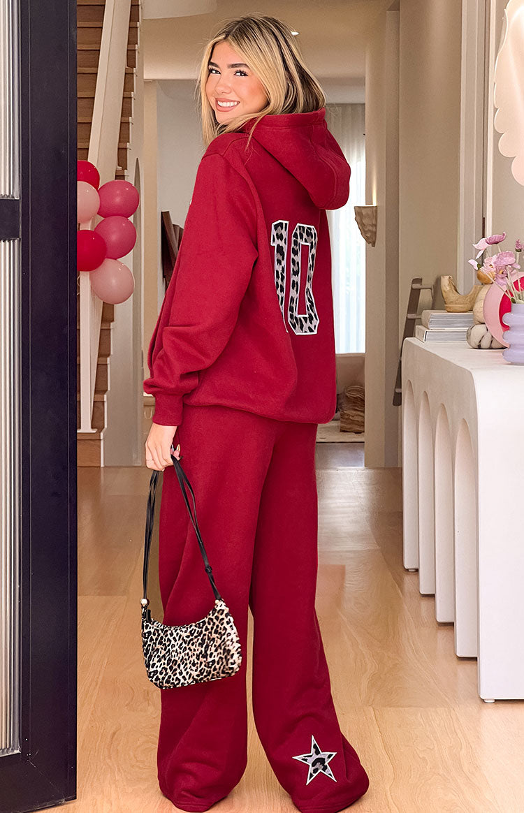 Rear view of a burgundy hoodie with a leopard print "10" graphic on the back and matching pants with a leopard star