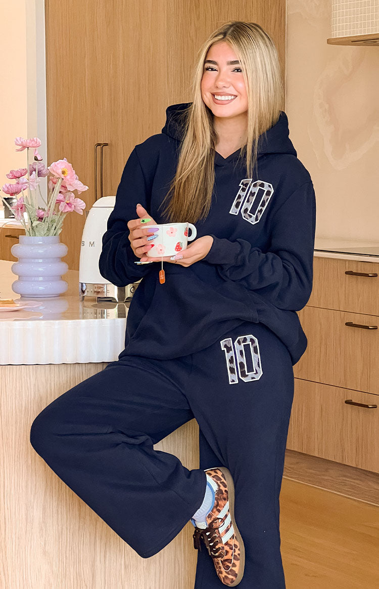 A navy blue outerwear consisting of a hooded sweatshirt best pair with wide-leg pants both featuring a white number 10 with a cow print pattern.
