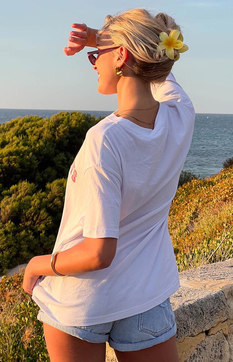Side view of a white relaxed fit tee with short sleeves and a subtle V-neck
