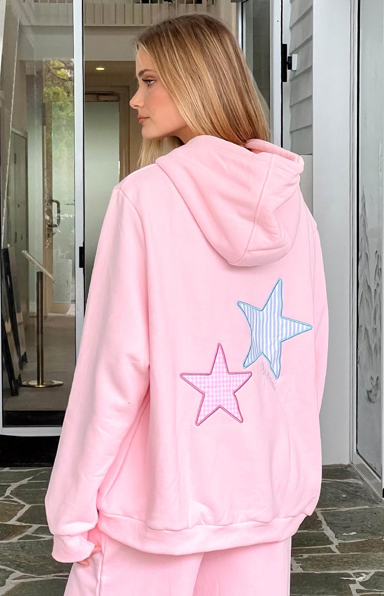 Back view of a pink hoodie with a blue striped star and a pink gingham star applique