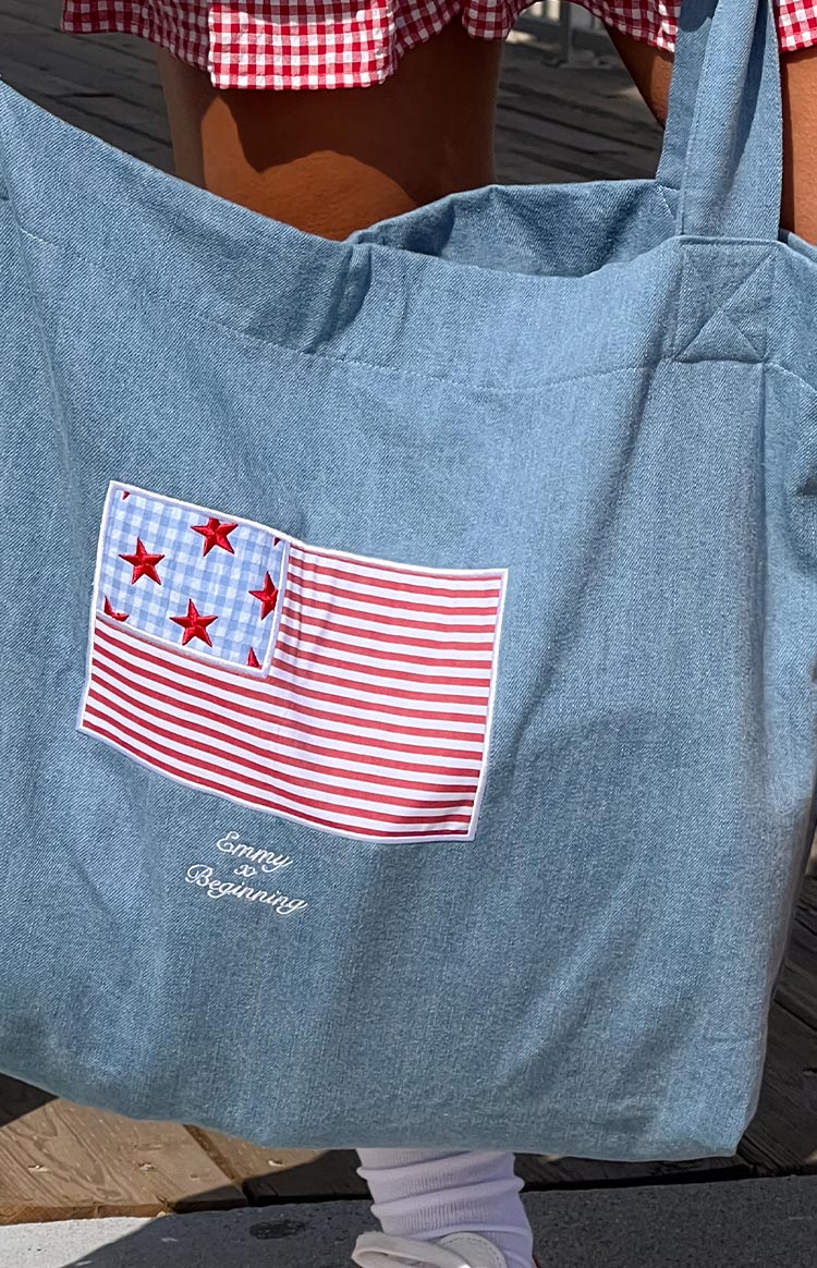 Model wearing a denim tote bag with a red and blue USA flag applique