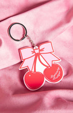 Close-up of the red and pink cherry bow keyring showing the Beginning Boutique text on one cherry