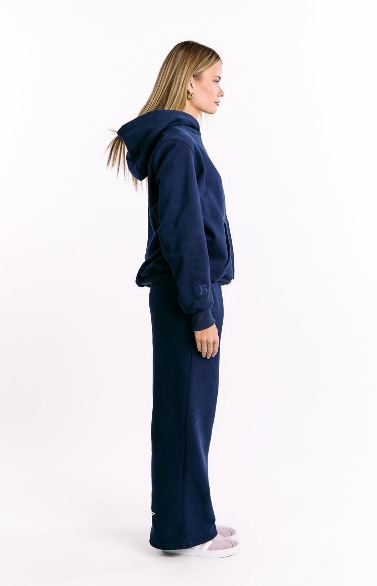 Side view of a navy relaxed fit hoodie with a hood, long sleeves, and embroidered BB logo on the cuff