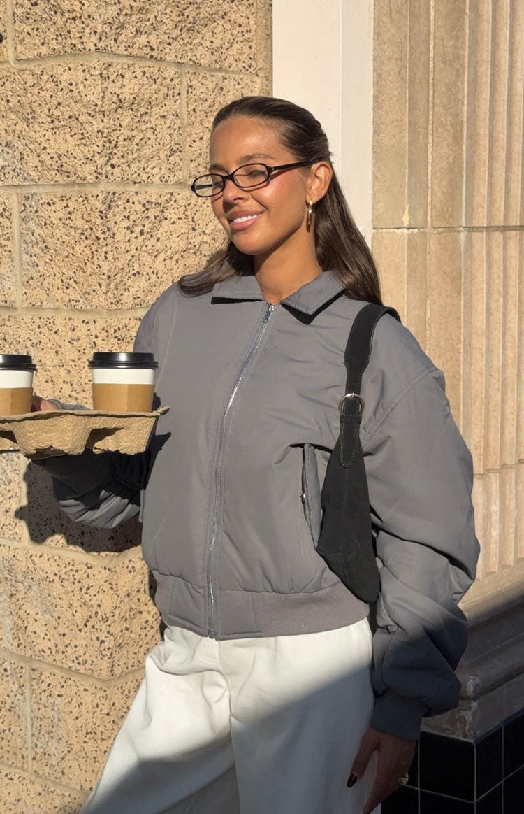 Front view of a grey puff bomber jacket with a pointed collar, full silver zip, and ribbed cuffs and hem