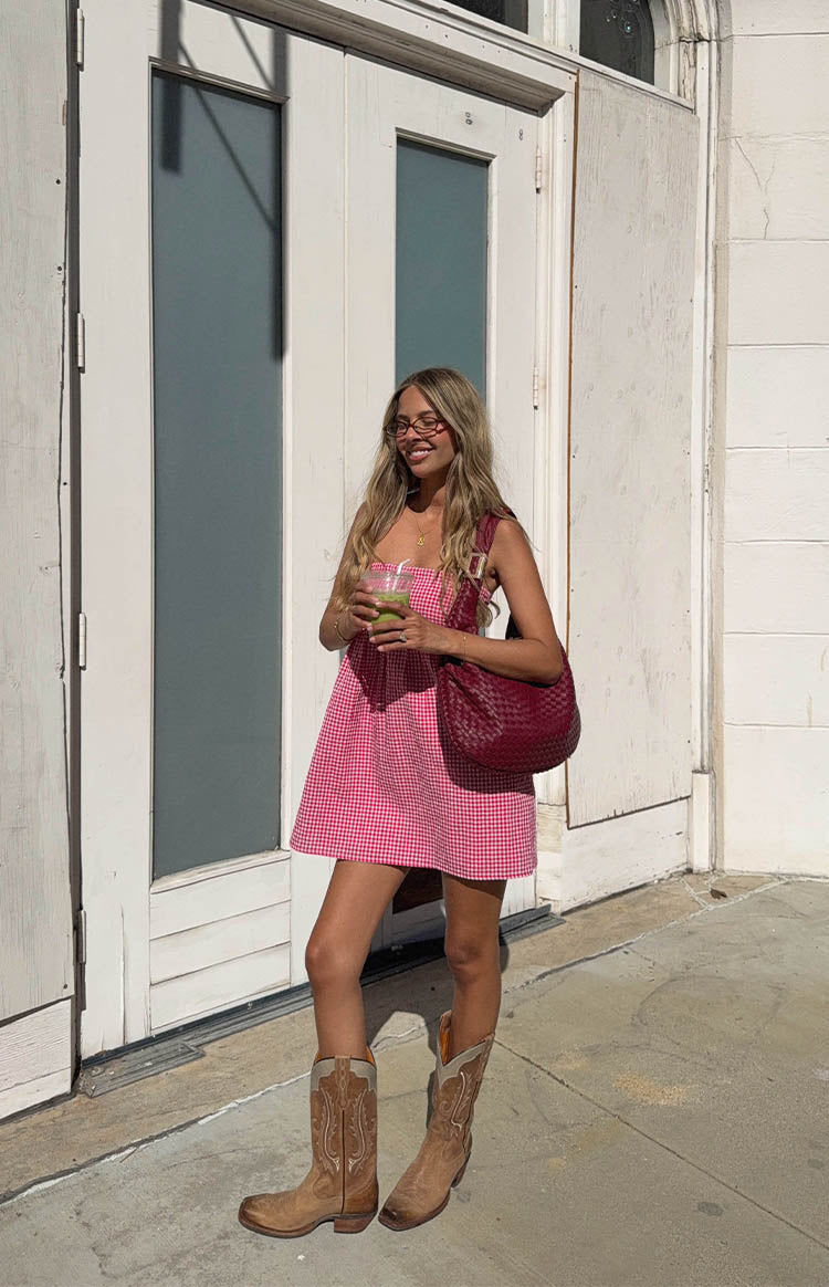 Full length view of a red gingham mini dress with thin shoulder straps and a relaxed A-line fit