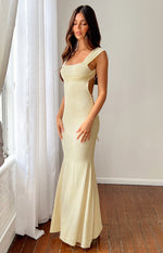 Side view of a cream mesh maxi dress with ruched bodice, thick straps, open lace-up back, and mermaid silhouette