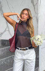 Front view of a black sheer high neck sleeveless top with a relaxed, flowy fit
